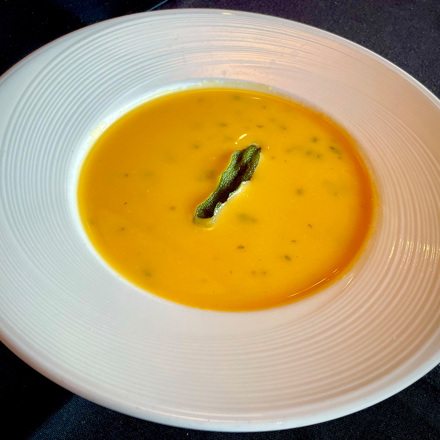Butternut Squash Bisque with Sage in white bowl