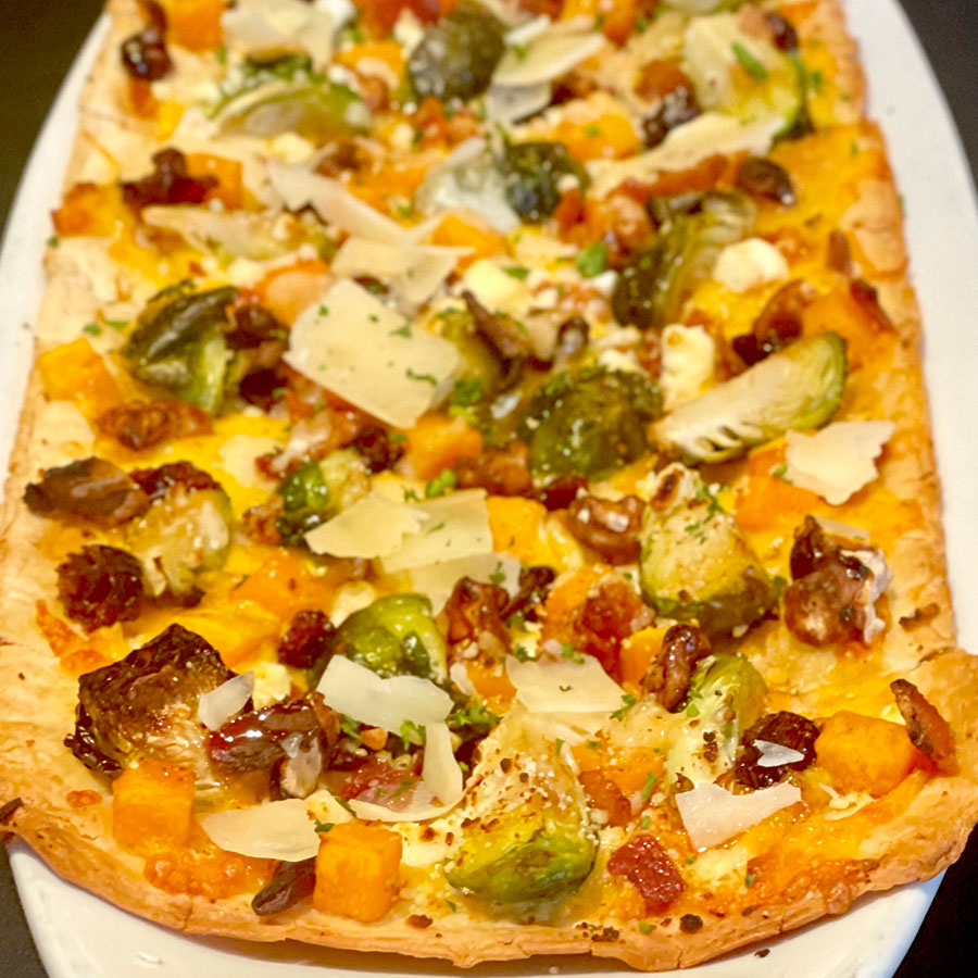Roasted Brussels Sprouts Flatbread with Roasted Brussels Sprouts Butternut Squash Flatbread | $14.49 smoked cheddar, cranberries, walnuts, bacon, goat cheese, parmesan, hot honey