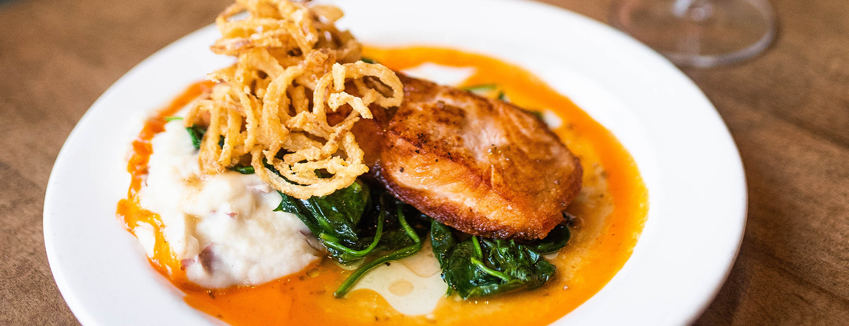 Seared Verlasso Salmon - plated with mashed potatoes, crispy onions and sautéed spinach.