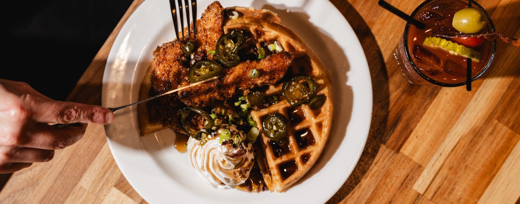 Overhead view of chicken and waffles with a bloody mary