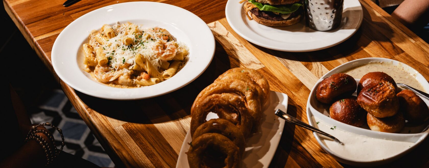 Overhead view of Matt's Burger, rigatoni, onion rings and pretzel bites