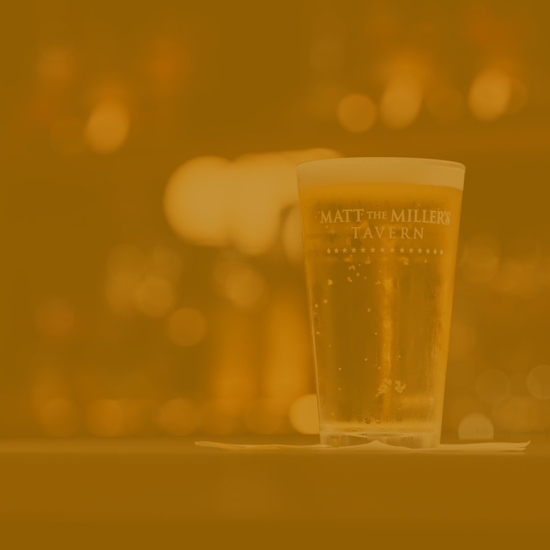 Draft beer in a Matt the Miller's Tavern pint glass on the bar
