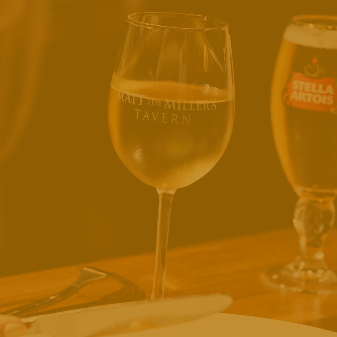 Glass of white wine in a Matt the Miller's Tavern glass
